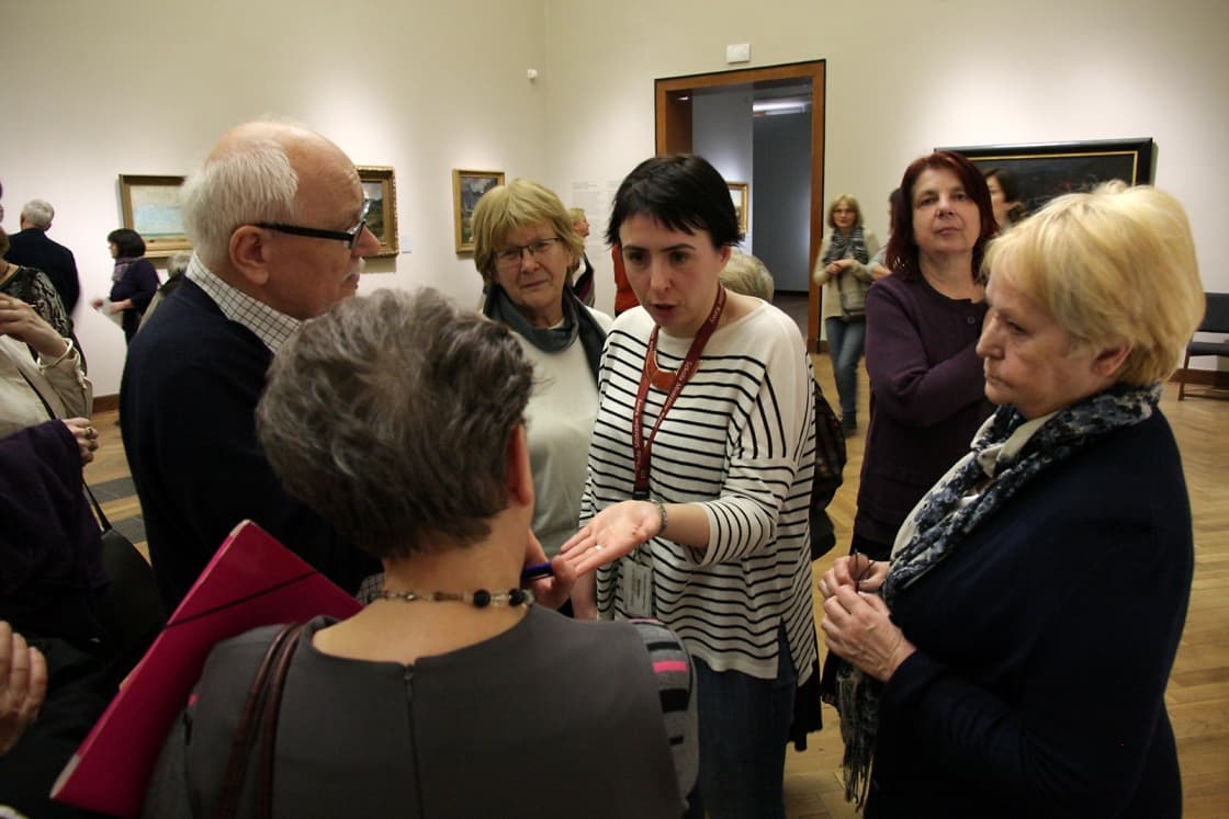 Zdjęcie przedstawiające grupę z przewodnikiem w galerii